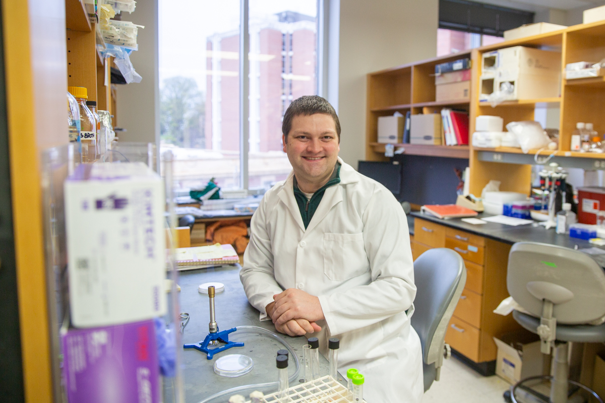 Man in lab coat sitting at his work station