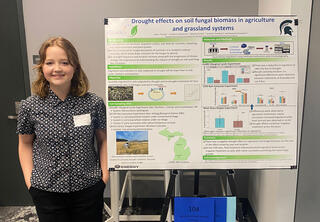 Woman with red hair standing next to poster presentation