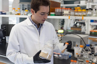 Man in white lab coat holding test tube