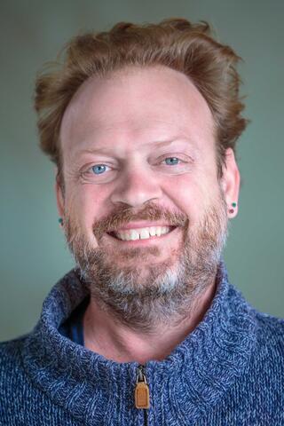 Smiling man with redish hair and beard