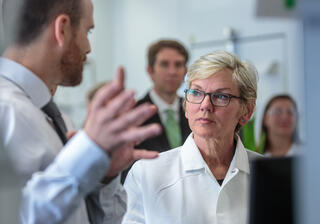 Researcher talks to official in lab