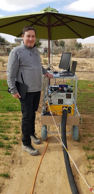 Man standing next to equipment in a field