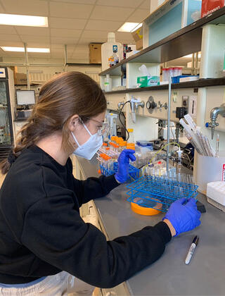 Lina Blanco holding a tray of test tubes