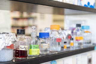 A shelf of glass jars with lids and labels of various colors