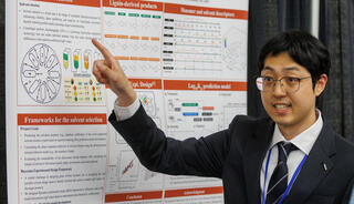Man gesturing in front of a poster