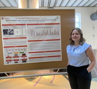 Christine Stark standing in front of a poster. 