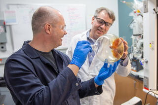 Researchers examine vial in lab