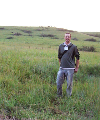 Tyler Lark stands in a grassland