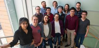 Members of Ophelia Venturelli's lab pose for a group photo in a stairwell.