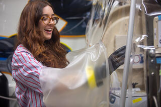brunette woman places hands inside of glovebox.