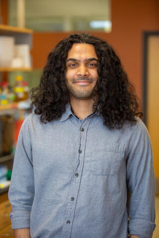 Daven stands in lab looking at camera.