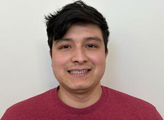 Smiling man with black hair in red T-shirt