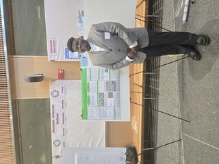 Williams stands in front of a scientific poster